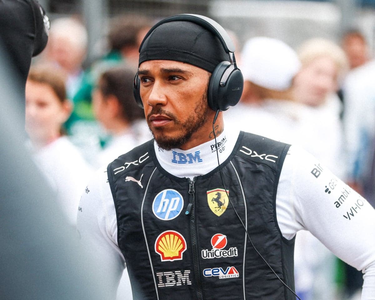 Lewis Hamilton in racing gear, wearing headphones
