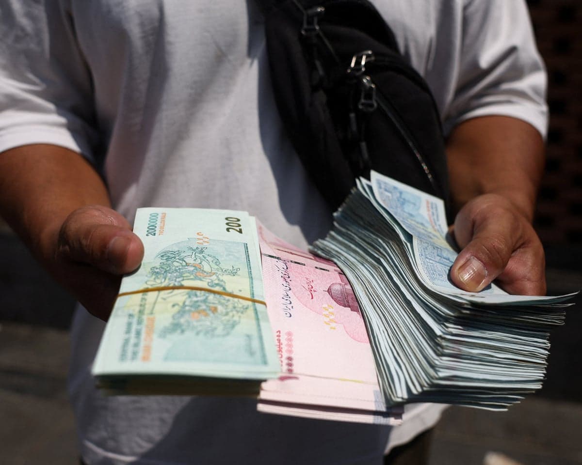 A currency dealer holds Iranian rial in the Grand Bazaar in Tehran, Iran, on 17 August.
