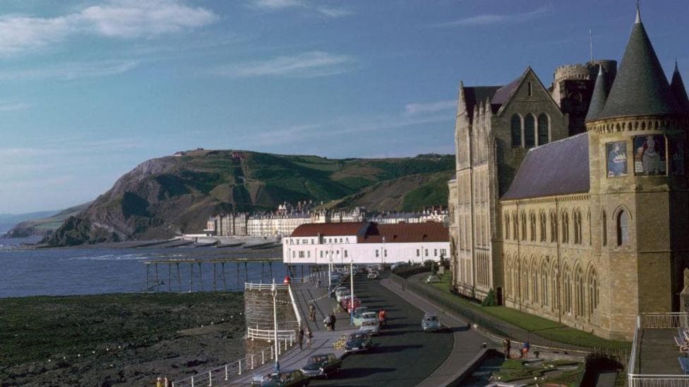 A general view of Old College, a tall brick building overlooking a bay.