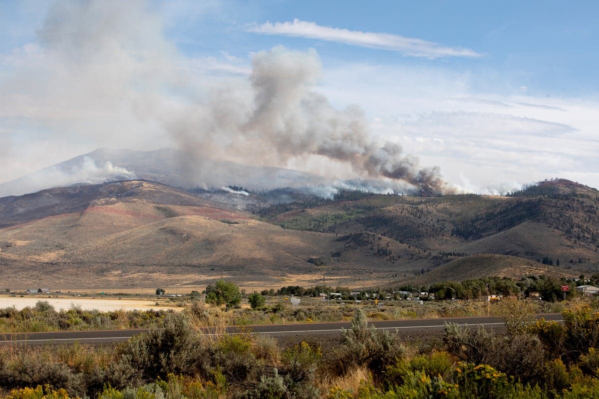 smoke billows from a fire in distance