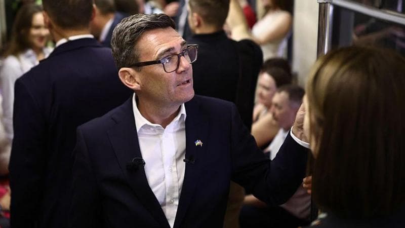 Andy Burnham reacts as he stands in a metro carriage among passengers during the journey between the metro stations Zoloti Vorota and Lukanivska on August 24, 2026 in Kyiv, Ukraine.
