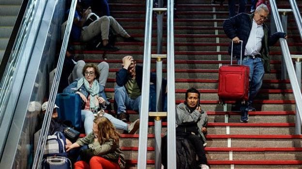 Passengers looking stressed while sitting on the steps of Atocha train station during April's power cut.