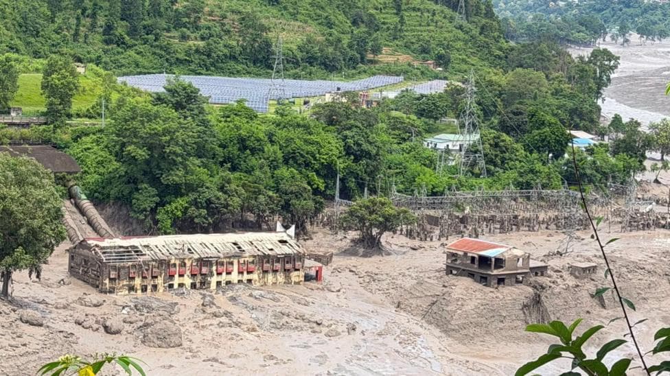 Mud and sand are piled up against a hydropower plant affected by a flash flood in northern Nepal
