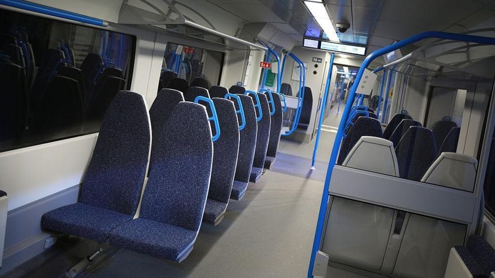A row of dark blue seats on a train.