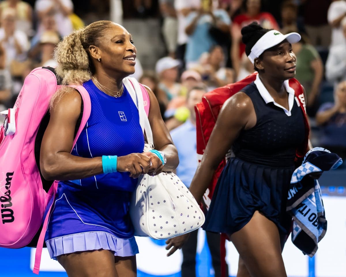 Serena and Venus Williams walk off the court after their loss at the Cincinnati Open.