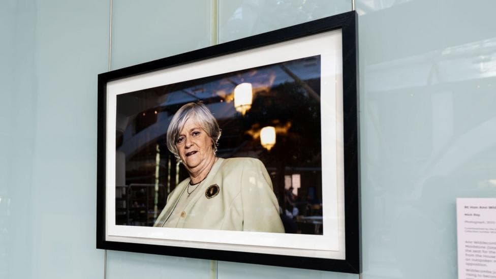 A framed photograph of Ann Widdecombe in a black frame on a wall in Portcullis House.