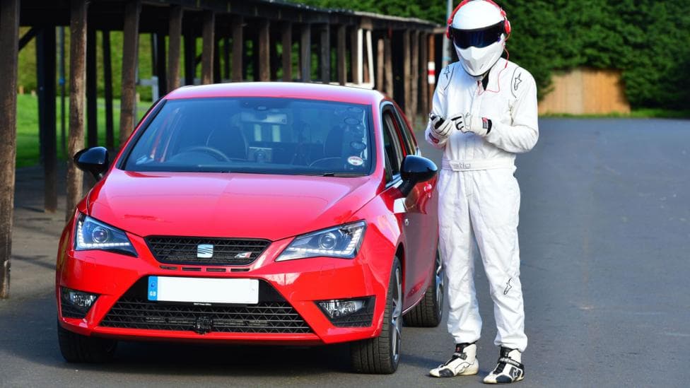 The Stig by a red car