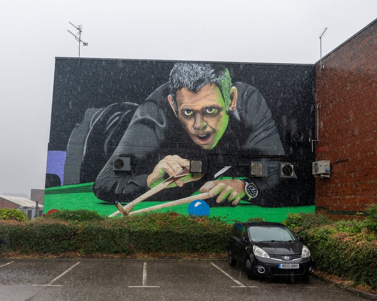 A large mural of Ronnie O'Sullivan leaning over a snooker table