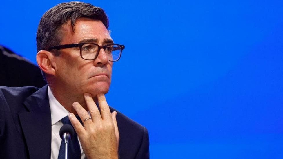 Andy Burnham looks pensive as he puts his hand to his chin and looks sideways.