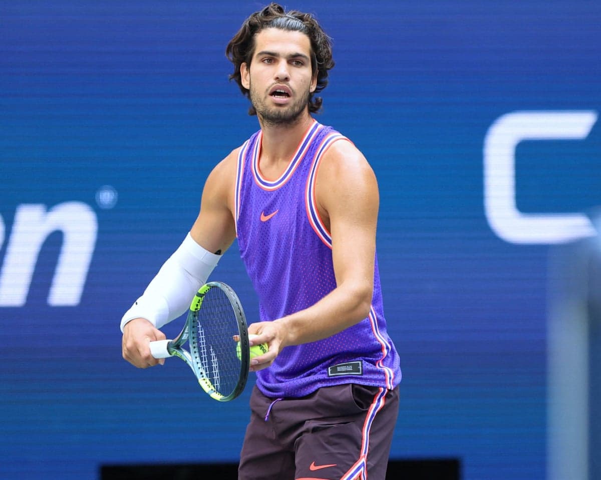 Carlos Alcaraz prepares to serve during thew US Open mixed doubles, in which he competed with Serena Williams