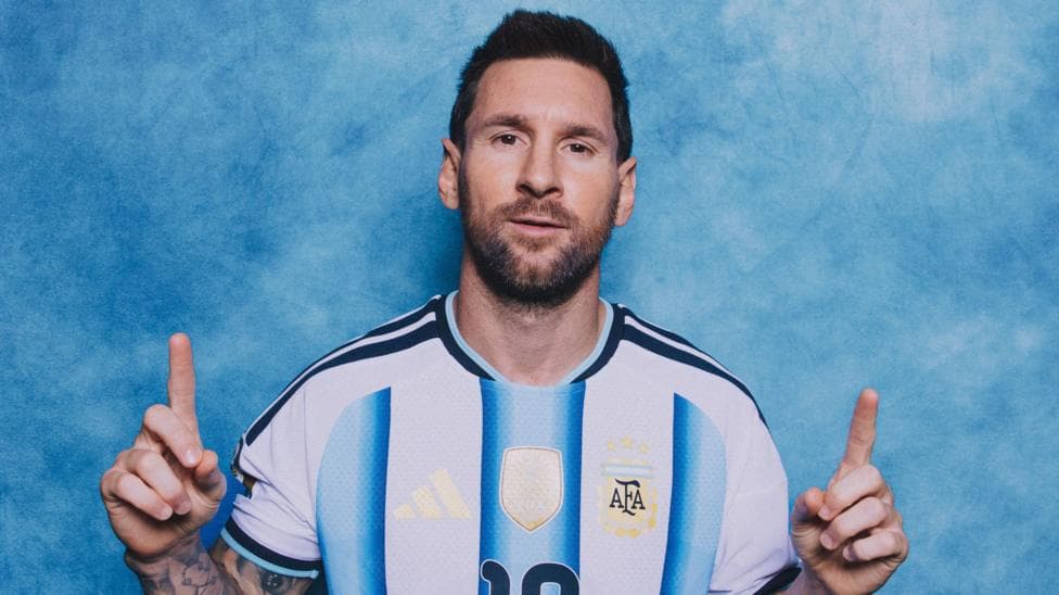 Lionel Messi poses in a photoshoot, with the index fingers of both hands pointing upwards