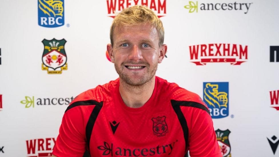Joe Worrall pictured signing his Wrexham contract.