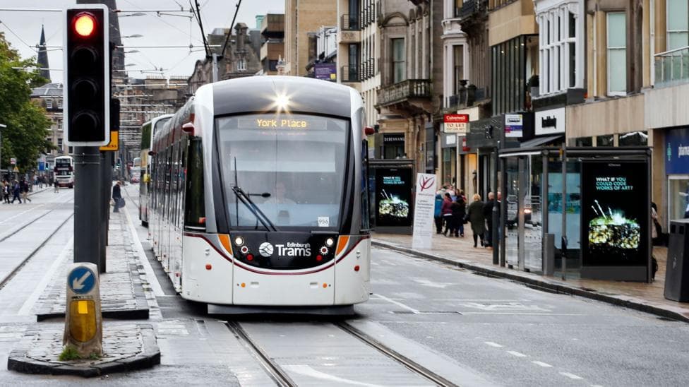 A tram travelling along Princes Street in Edinburgh on a wet day.