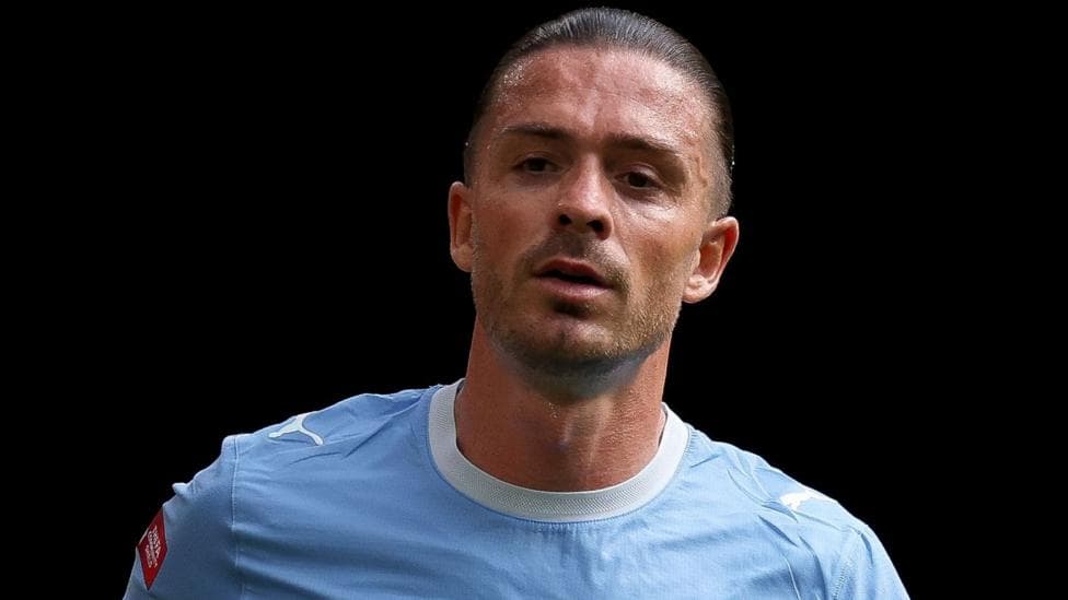 Jack Grealish, wearing Manchester City's sky blue kit, looks on during a match
