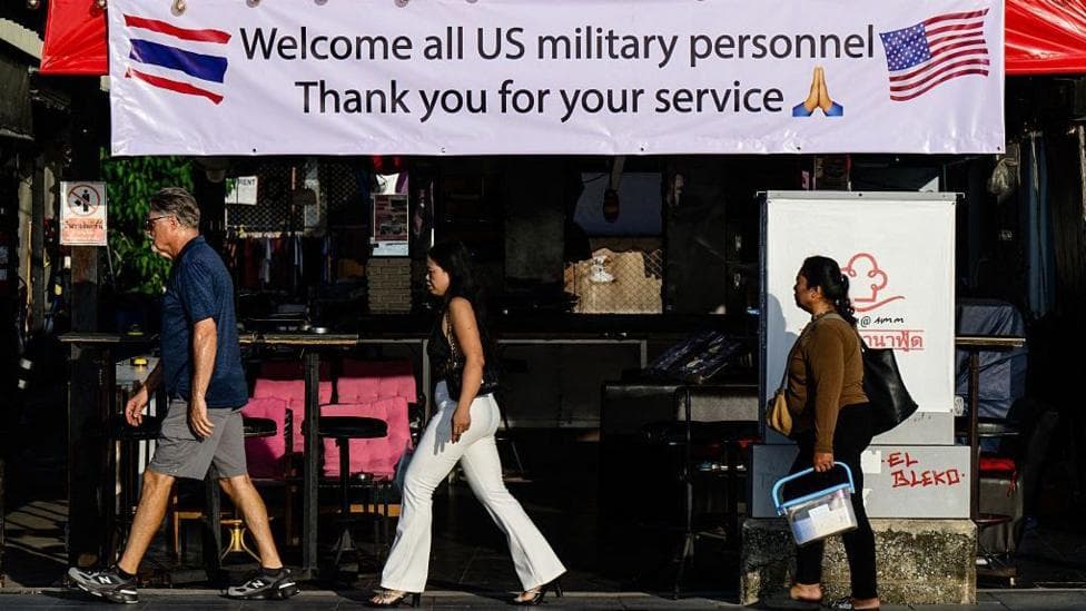 Pedestrians walk past a banner welcoming US military personnel displayed outside a bar in Pattaya on September 1, 2026.