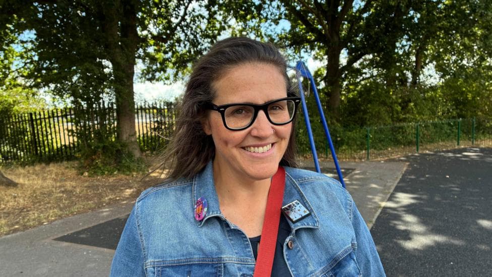 Kay Devonshire-Murphy standing in a playground in front of a swing