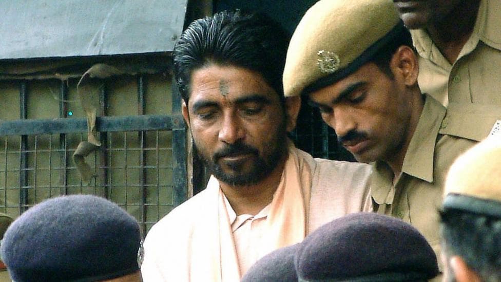 Dara Singh is surrounded by police officers as he arrives at a special court in Bhubaneshwar, 15 September 2003. Pal is amongst 13 people found guilty of the January 23, 1999, murder in eastern India of Australian missionary Graham Staines and his two sons. AFP PHOTO (Photo credit should read STR/AFP via Getty Images)