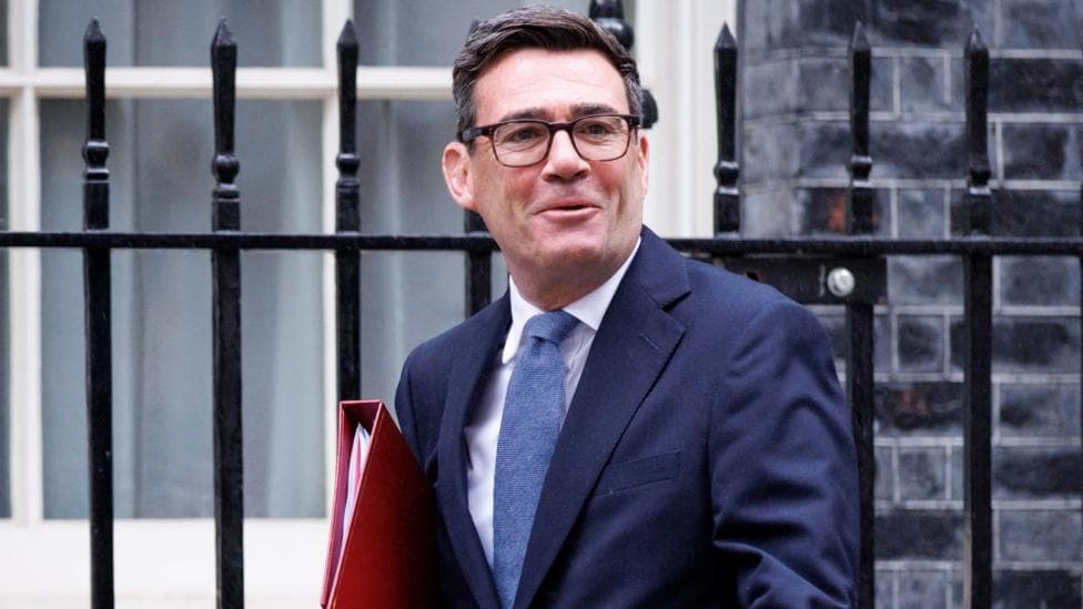 PM Andy Burnham is out the front of 10 Downing Street holding a red folder.
