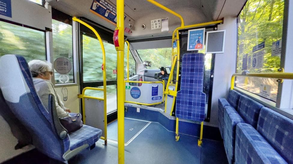 A woman sits on a pass as it travels through Glasgow.