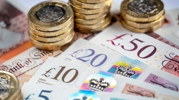 One pound coins stacked on top of notes.