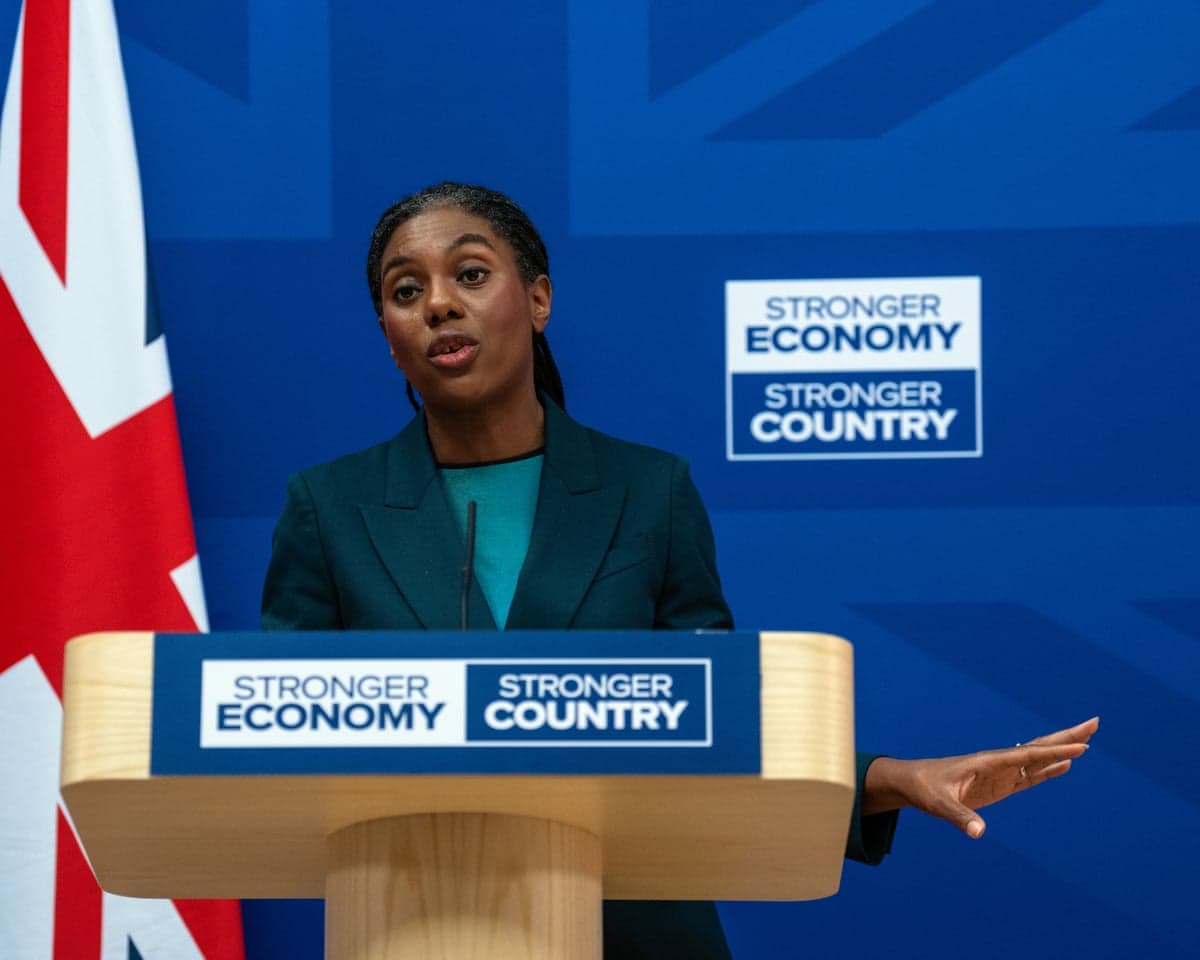 Kemi Badenoch speaks at a press conference at a lectern with the slogan: stronger economy stronger country. There is a union jack flag behind her.