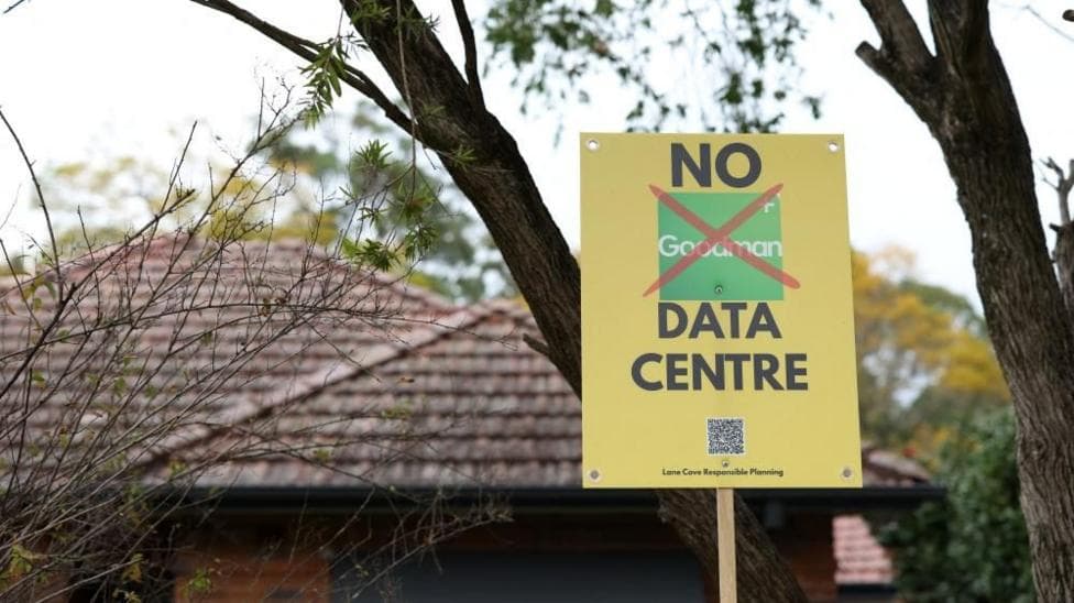 A yellow placard reading 'No data centre' in front of a house and trees