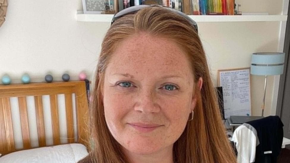A woman with ginger hair looking at the camera.