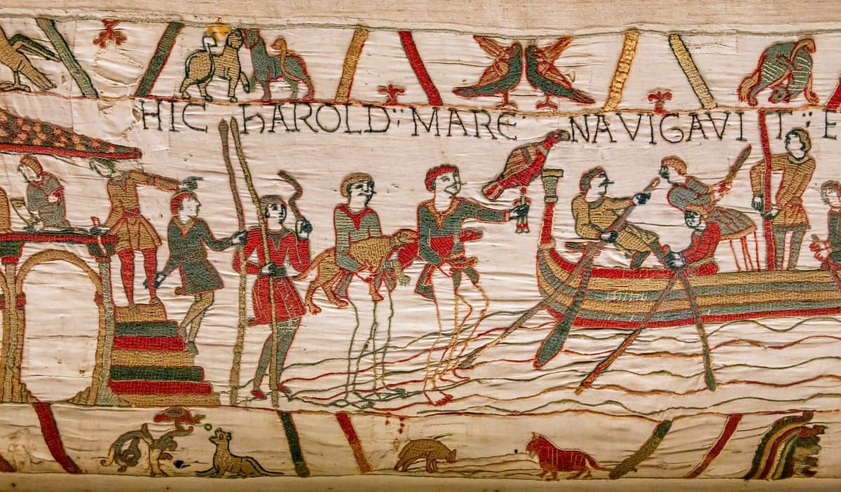 Bayeux Tapestry scene showing Harold's men boarding a ship, with Latin text above