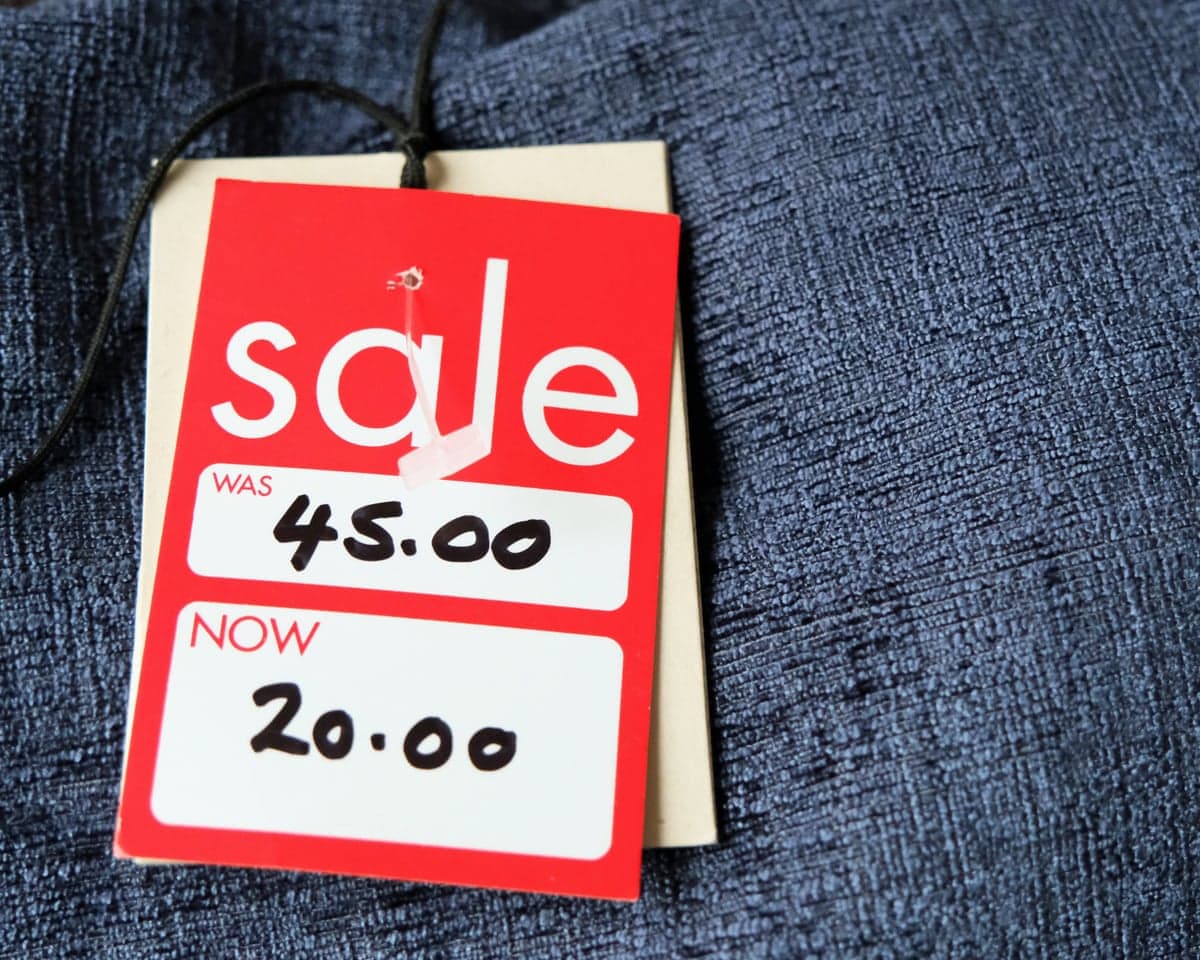 Red and white tag showing a price reduction on a garment, was £45, now £20