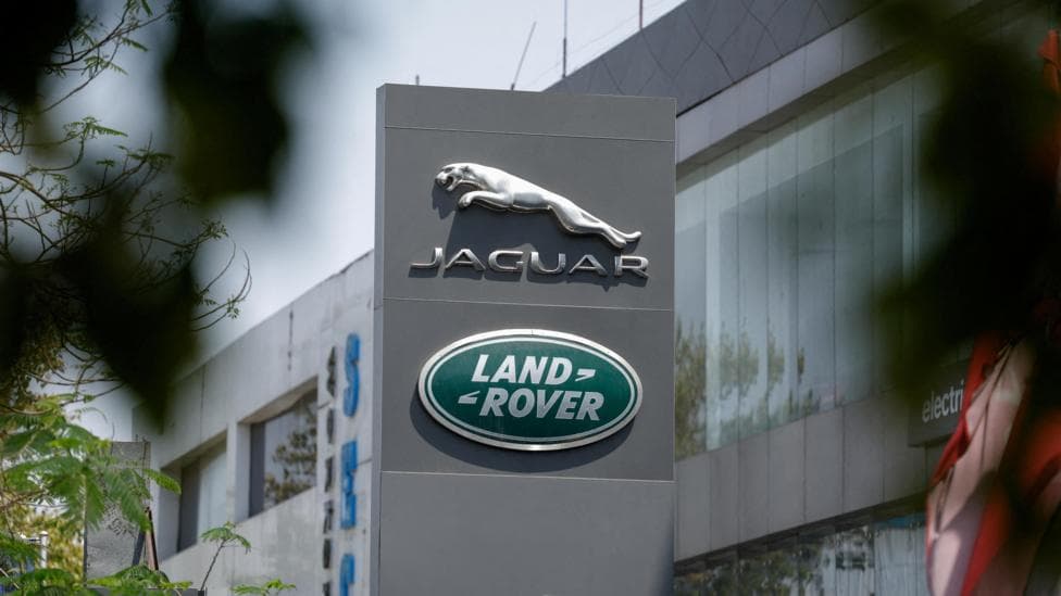The silver leaping Jaguar emblem is on a grey pillar sign outside one of its factories with the green, oval Land Rover badge below.