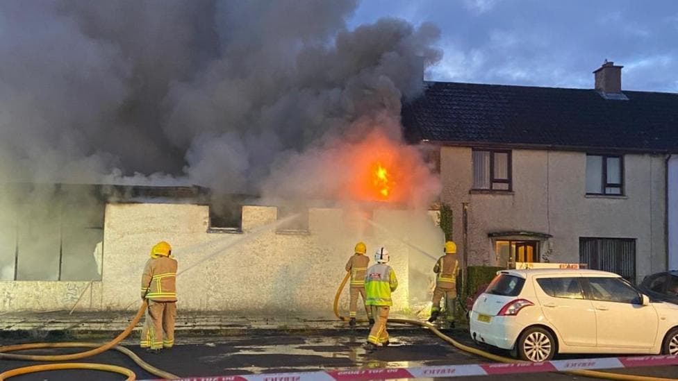 Firefighters putting out a fire at a building.