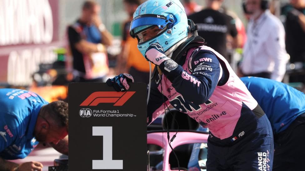 Alpine's Pierre Gasly poses with a picture of the '1' board after taking pole position at the Italian Grand Prix