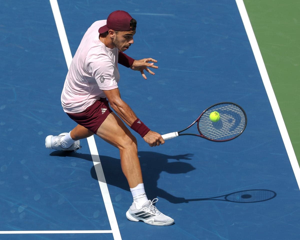 Francisco Cerundolo plays a shot against Taylor Fritz