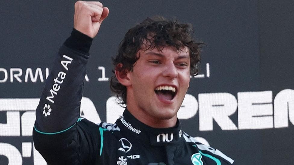 Kimi Antonelli smiles and clenches his right fist in celebration on the podium after winning the Italian Grand Prix