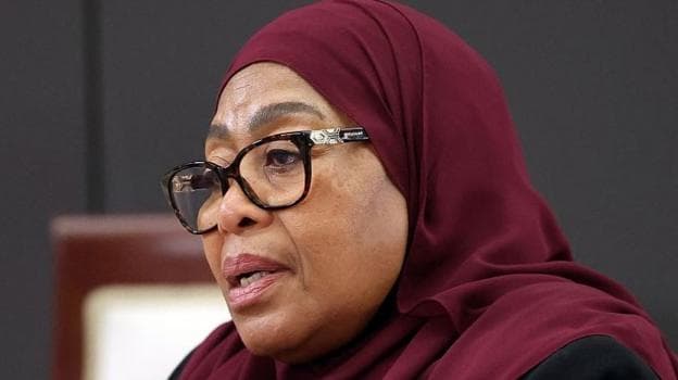 The president wearing a maroon hijab and black-rimmed glasses