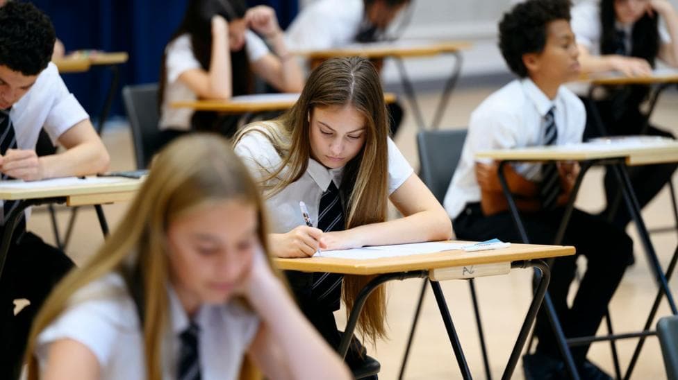 Secondary school girl with long straight hair sitting exam and concentrating.