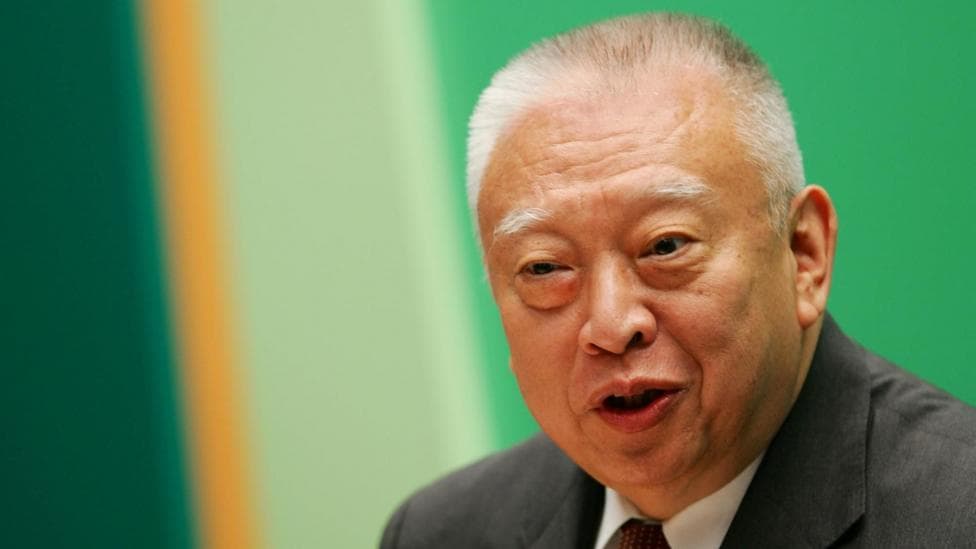 Tung Chee-hwa wearing a dark suit and white shirt