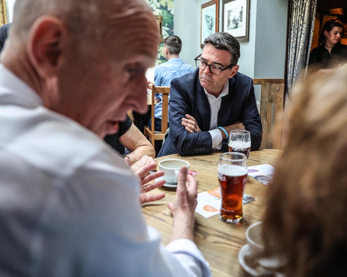 Burnham and Healey sat at wooden table with part-drunk pints of beers chatting with locals