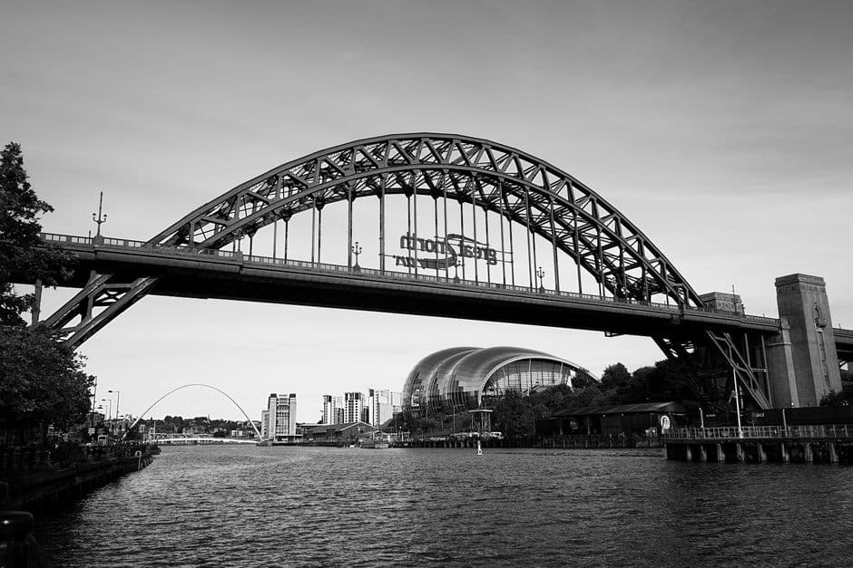 Stunning black and white capture of the iconic Tyne Bridge over River Tyne with skyline view.