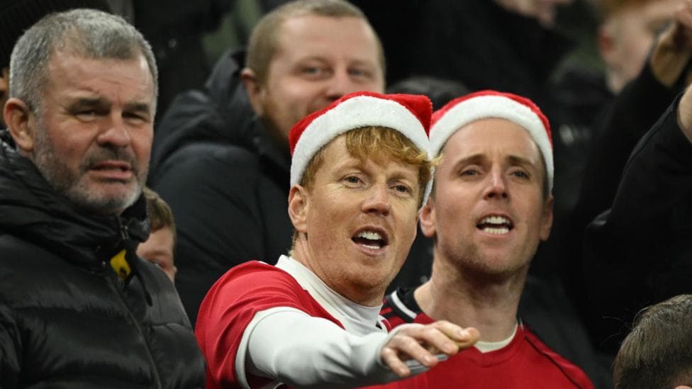 Manchester United fans wearing Santa hats at a match on 21 December 2026