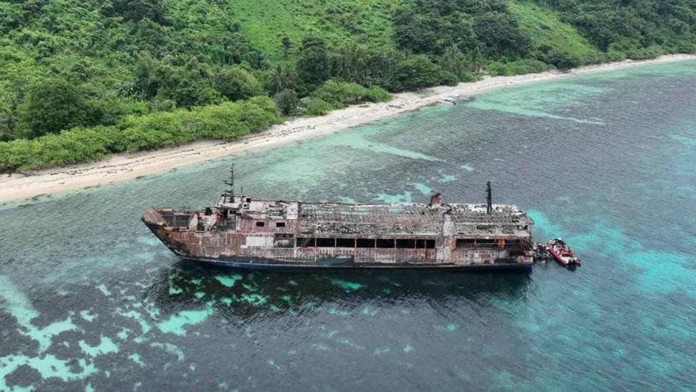 A handout photo made available by the Philippine Coast Guard shows an aerial view of a burnt ferry off Palawan province.