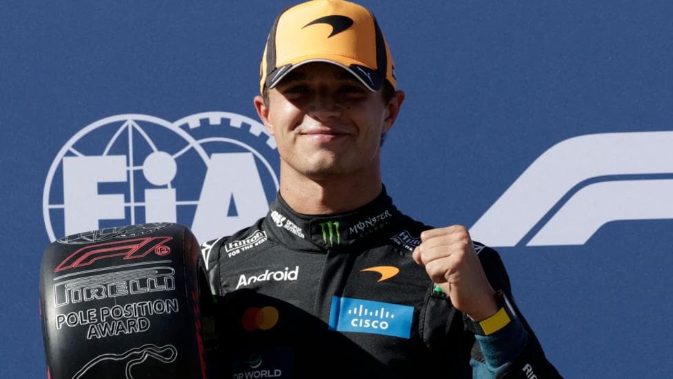 Lando Norris clenches his left fist in celebration while holding the pole position award at the Spanish Grand Prix