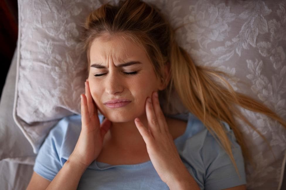 Jaw pain after waking up or sleeping - Bruxisum, teeth grinding - stock photo