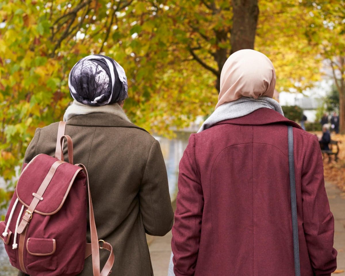 Two Muslim women walking in a park
