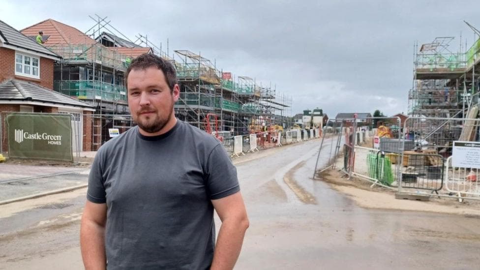 Nathan Long stands in a street of partly built homes