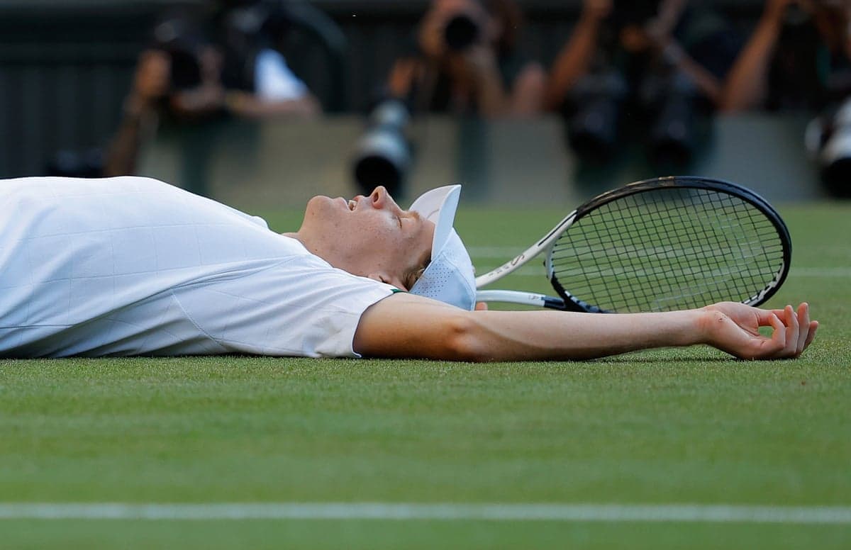 Jannik Sinner lies on the grass after winning Wimbledon 2026