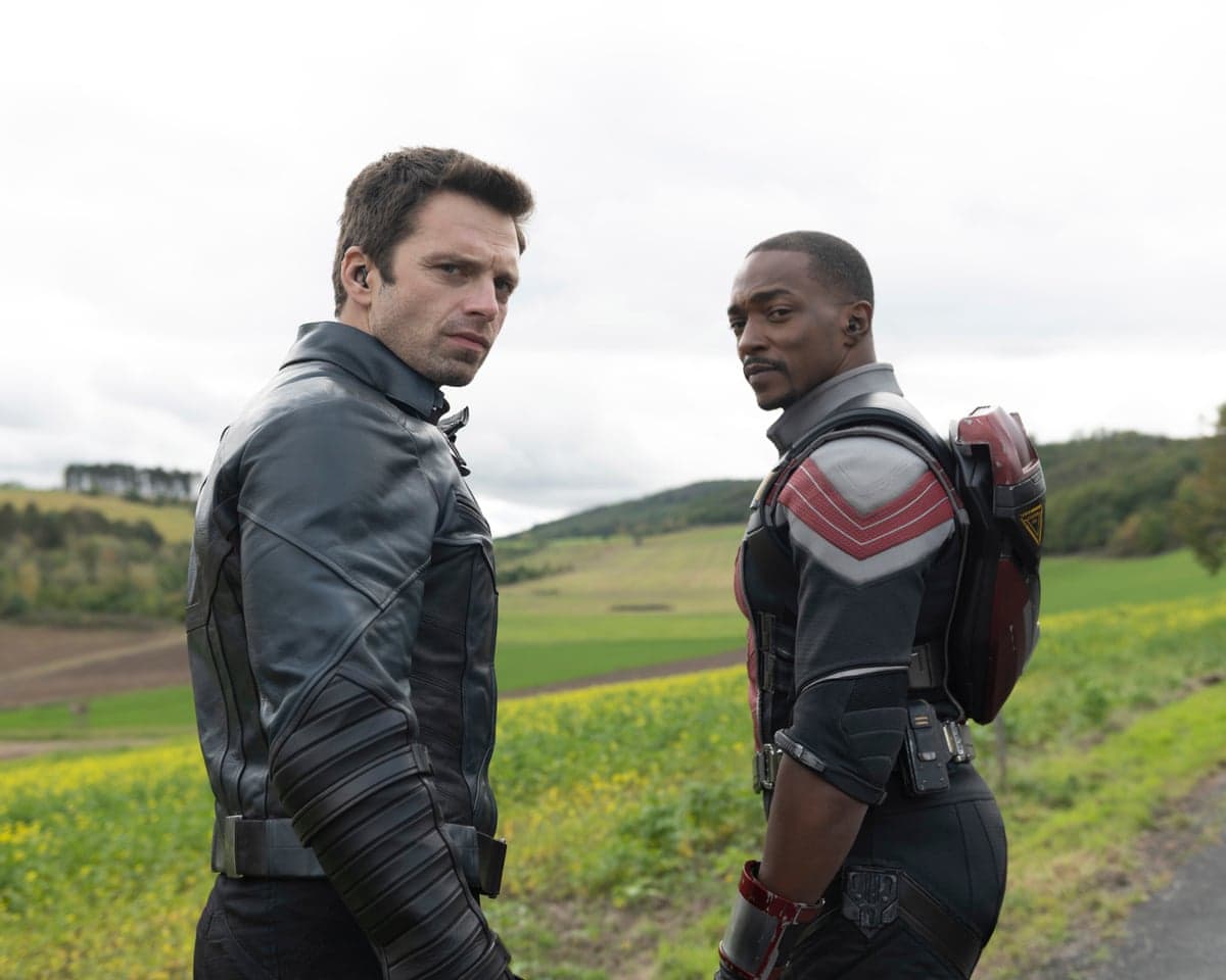 Bucky Barnes and Sam Wilson stand back-to-back looking over their shoulders in a field