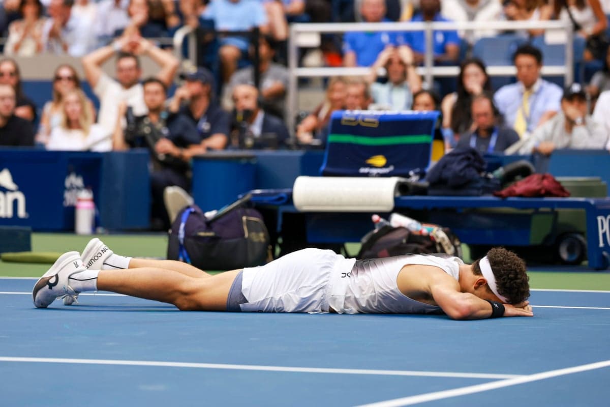 Ben Shelton lies face down on the court, head resting on his arms