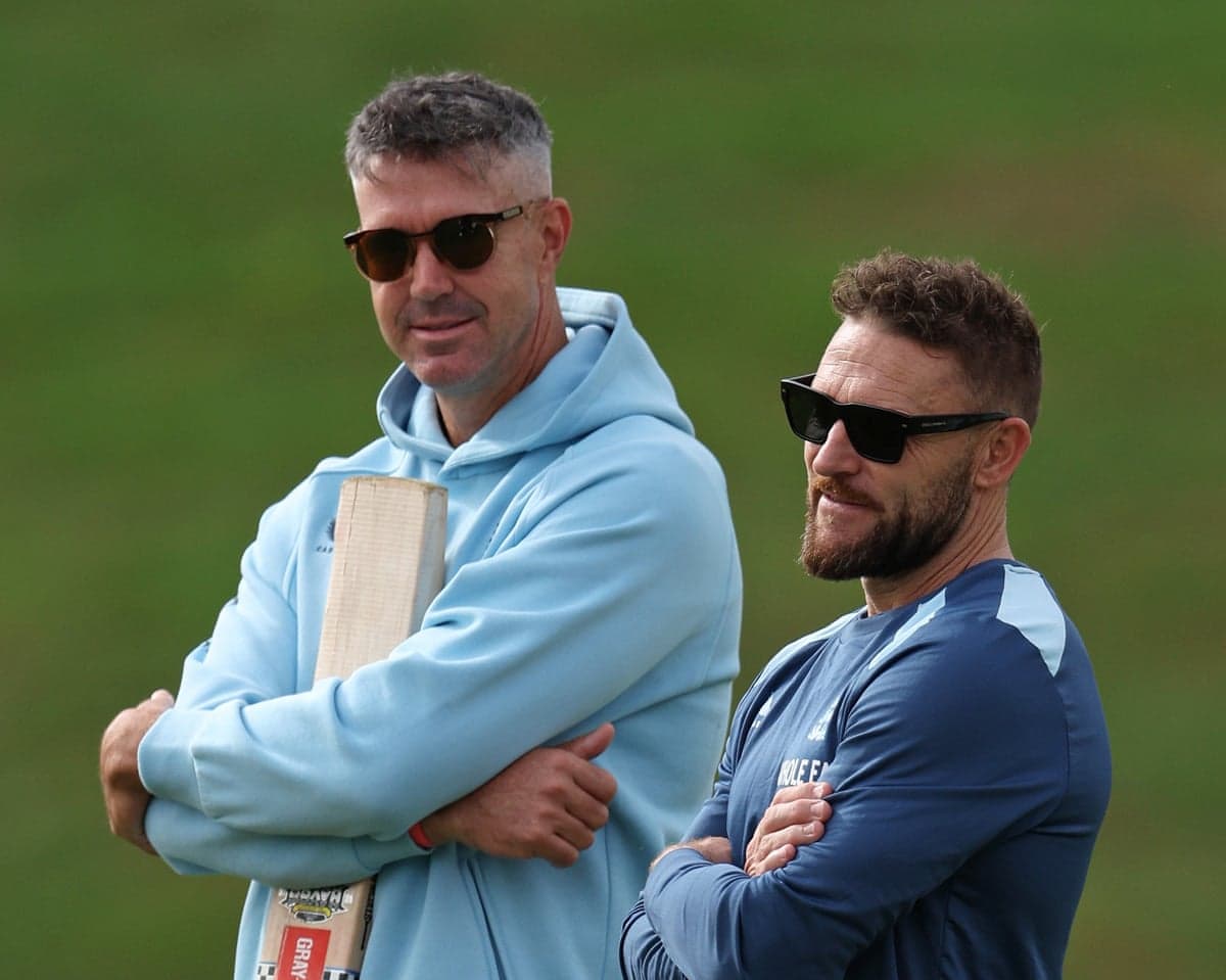 Kevin Pietersen and Brendon McCullum stand arms crossed at an England cricket nets session