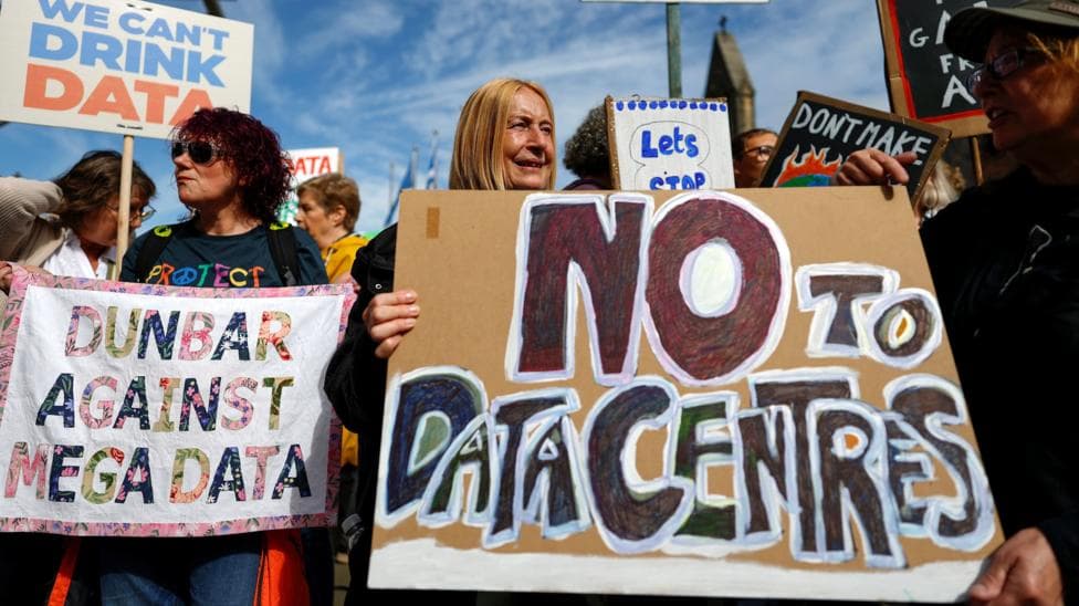 Activists gather protesting against data centres in their local area outside the Scottish parliament on the first Thursday after recess on September 03, 2026 in Edinburgh. One woman is holding a "NO TO DATA CENTRES" placard.